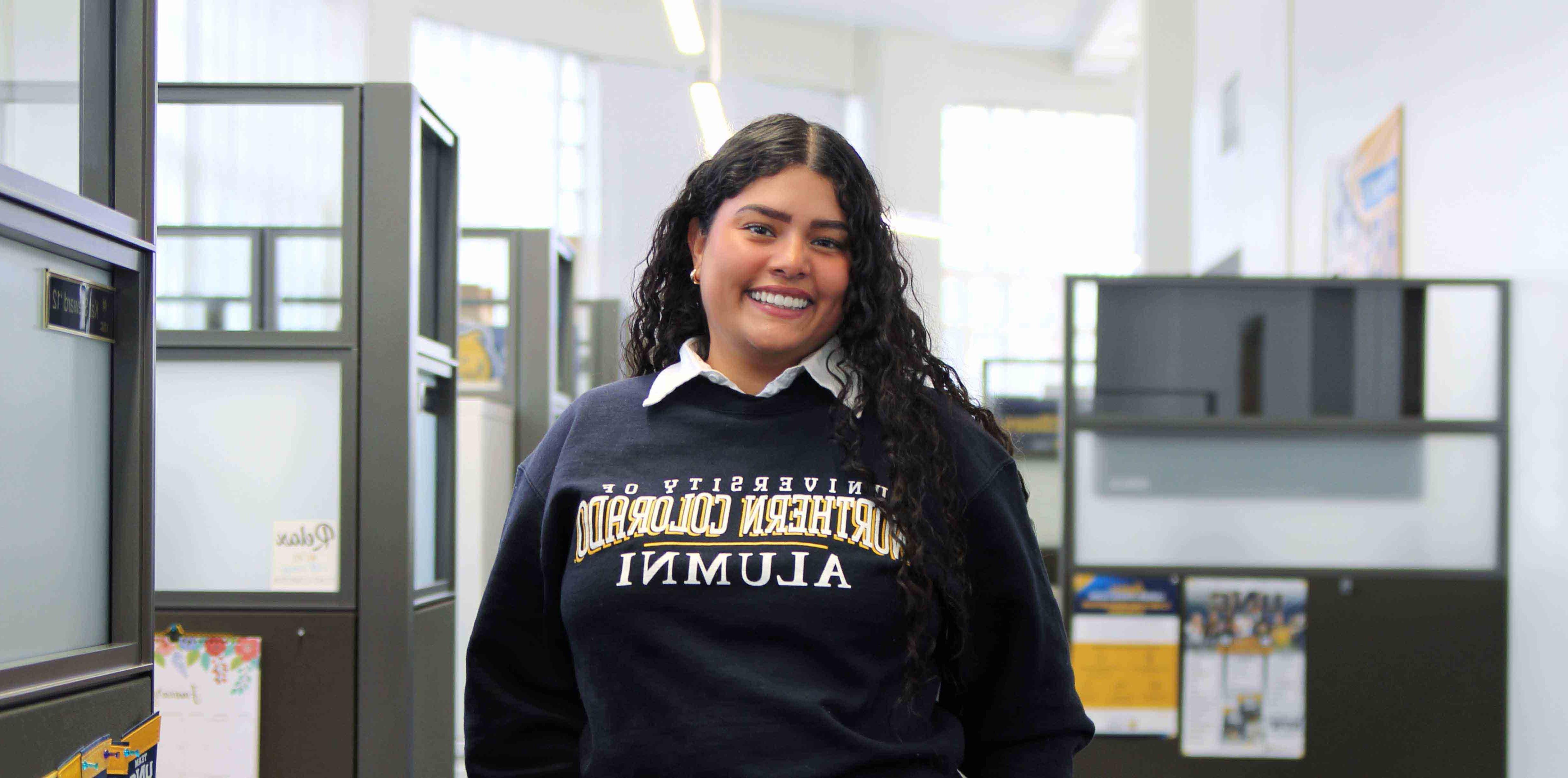 Teresa Castro smiles while standing in her office building.