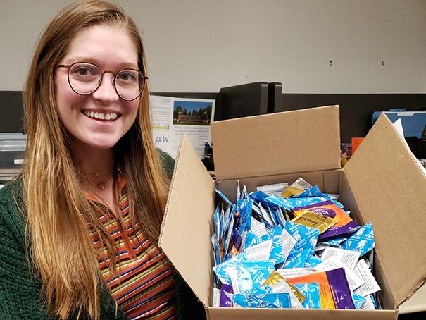 Brianna Kelly holding up the box of 500 condoms she won.