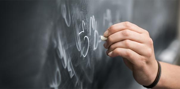 Student doing math equations on a chalkboard