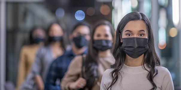 College students standing in a hallway wearing face masks