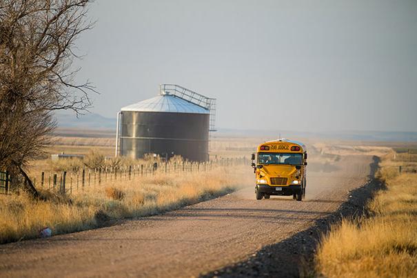 school bus driving on dirt road in rural Colorado