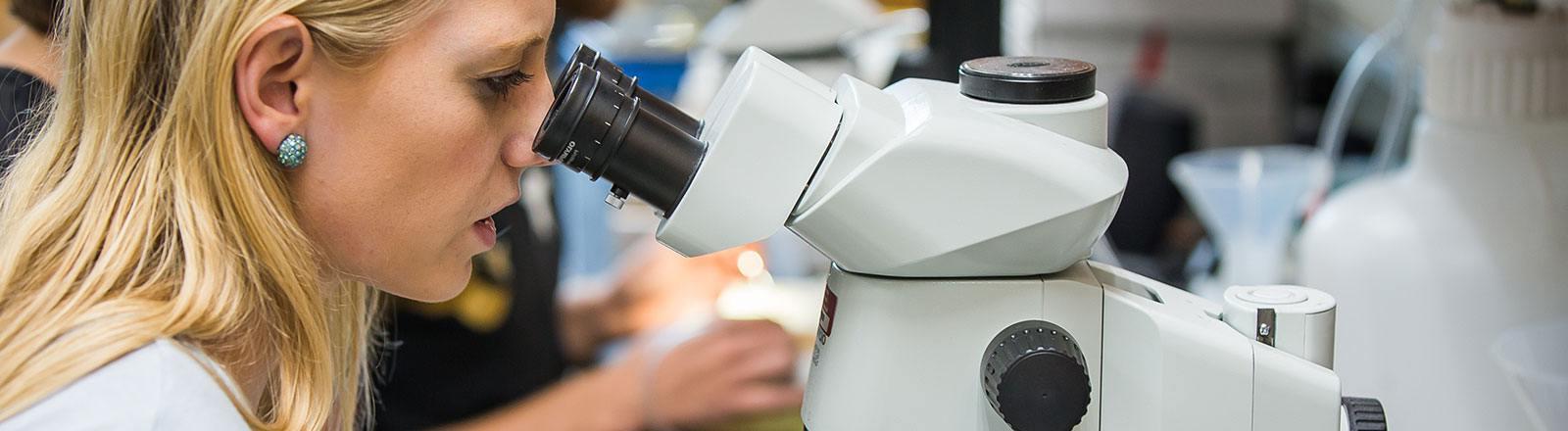 Student looking through microscope